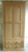 A pair of pine single wardrobes with two drawers under,