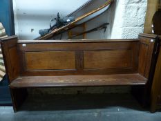 A small pine pew with panelled back,