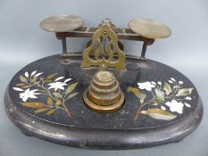 A late 19thC pietra dura postage scale with rates to pan and weights to base,
