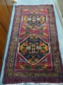 A fine Belouch rug on wine ground,