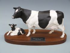 A Beswick Friesian cow and calf Connoisseur model on wooden plinth