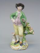 An 18thC figure of a man with dog,