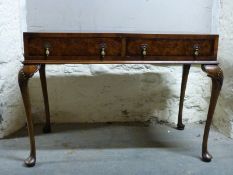 A leather inset walnut hall table / desk raised on cabriole legs with two drawers etc,