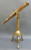 A brass telescope on tripod stand with screw focus and end cap,