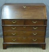 A Georgian mahogany bureau with four graduated drawers and fitted interior raised on bracket feet,