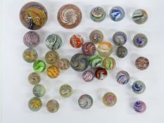 Thirty-nine handmade glass marbles including multi-coloured latticino examples,