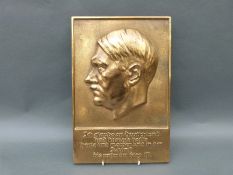 A German brass or bronze plaque of Adolf Hitler with motto below,