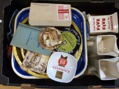 Two trays of breweriana including vintage beer mats, tea towels including Babycham,