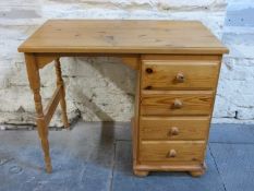 A small pine desk with four drawers,