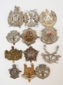 Thirteen various military cap badges to include machine gun guards, Tyneside Scottish,