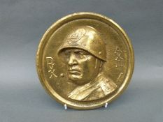 A brass plaque depicting Mussolini flanked by the letters DVX and AX III,