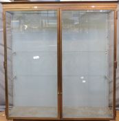 Ex Victoria & Albert Museum early 20thC two door glazed display cabinet with bronzed frame,