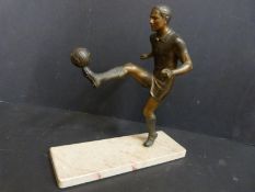 A Spelter figure of a footballer balancing a ball on marble plinth,