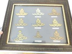 A display of nine Royal Artillery badges including Singapore, Hon Artillery Company,
