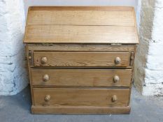 A pine bureau, the fall flap opening to reveal pigeon holes, the base fitted three long drawers,