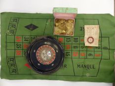 A vintage roulette wheel and guinea gaming tokens