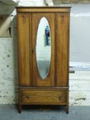 An oak single wardrobe with oval bevelled glass mirror,