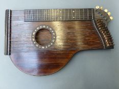 A 19thC Austrian lap zither with mother-of-pearl inlay decoration, five steel guitar strings,
