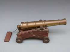 A late 19th/early 20thC bronze desk cannon and wooden carriage with bronze wheels with 10 inch