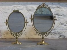 Two oval brass swing frame mirrors,