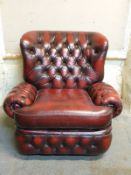 An oxblood leather button back Chesterfield armchair.