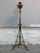 A 19thC Arts and Crafts style Evered & Co copper and brass oil lamp on wrought iron adjustable