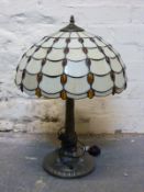 A Tiffany style table lamp and a further gilt example with geometric glass shade,