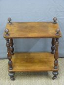 A 19thC two tier whatnot with turned supports raised on ceramic castors,