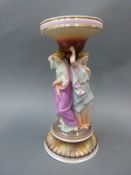 A German bisque centrepiece with bowl supported by three classical figures,