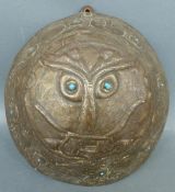 A late 19th/20thC Arts and Crafts hammered plaque, the central figure with phallic nose,