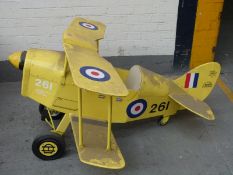 A child's pedal car in the form of a vintage biplane