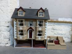 A three storey dolls' house with dormer windows and annexe,