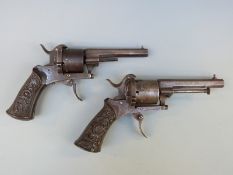 A matched pair of Belgian 7mm six-shot rim-fire revolvers with ornately carved grips,