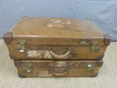 A pair of vintage leather bound suitcases with various labels including London and North Eastern