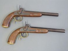 A pair of percussion hammer action pistols with chequered grip, ornate engraving to the locks,
