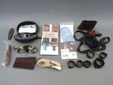 A collection of gun or shooting accessories including Oakley shooting glasses with multiple lenses,