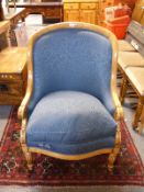 A 19thC tub or armchair with carved arms and reeded front legs