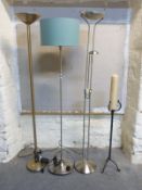 Three modern stainless steel standard lamps / uplighters and a torchere with candle