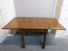 An oak extending dining table with fold over top and barley twist legs, min L72, max 144, W84,