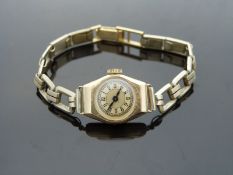 An 18ct gold ladies wristwatch with blued hands, black Arabic numerals and gold face,