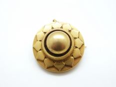 A Victorian yellow metal brooch with stylised floral design,