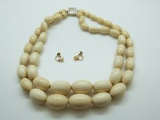 A two strand graduated ivory bead necklace and a pair of 9ct gold earrings set with ivory