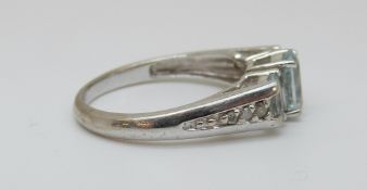 A 10K white gold ring set with blue topaz and diamonds to the shoulders, size N, 2.