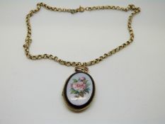 A Victorian oval locket with oval enamel plaque depicting roses on gilt textured chain