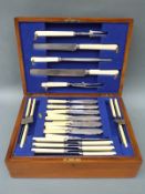 An oak cased part canteen of cutlery including carving set