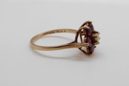 A 9ct gold ring set with an opal surrounded by rubies, size O, 2.