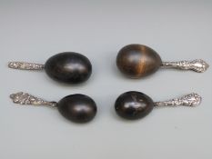 Four various white metal and hallmarked silver ebony darning or sewing eggs,