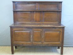 An oak sideboard with panelled back and doors,
