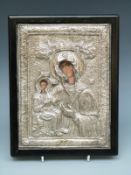 A white metal icon with decoration in relief,