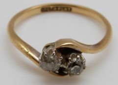 An 18ct gold ring set with two diamonds in a twist setting,